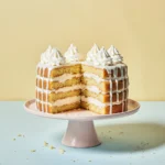 A fluffy Twinkie Cake with creamy layers, sliced and served on a pastel plate with whipped topping.